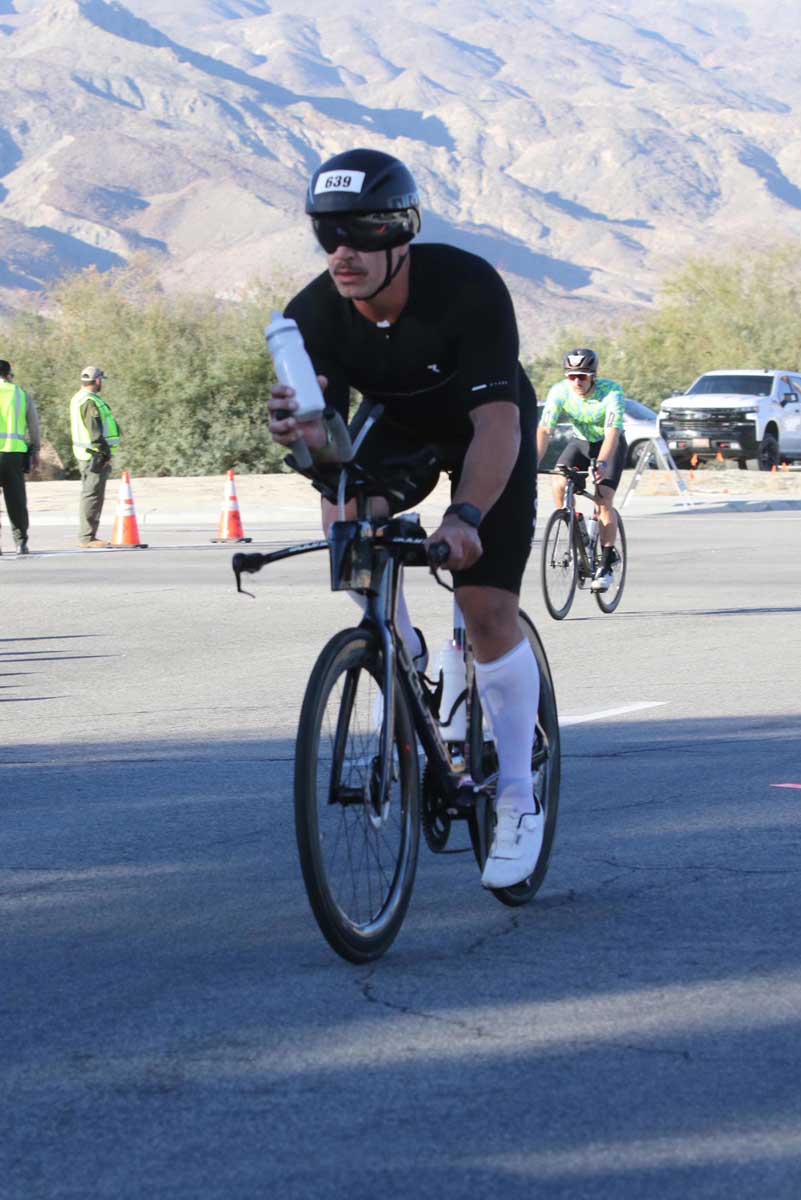 The coach is riding a bike.