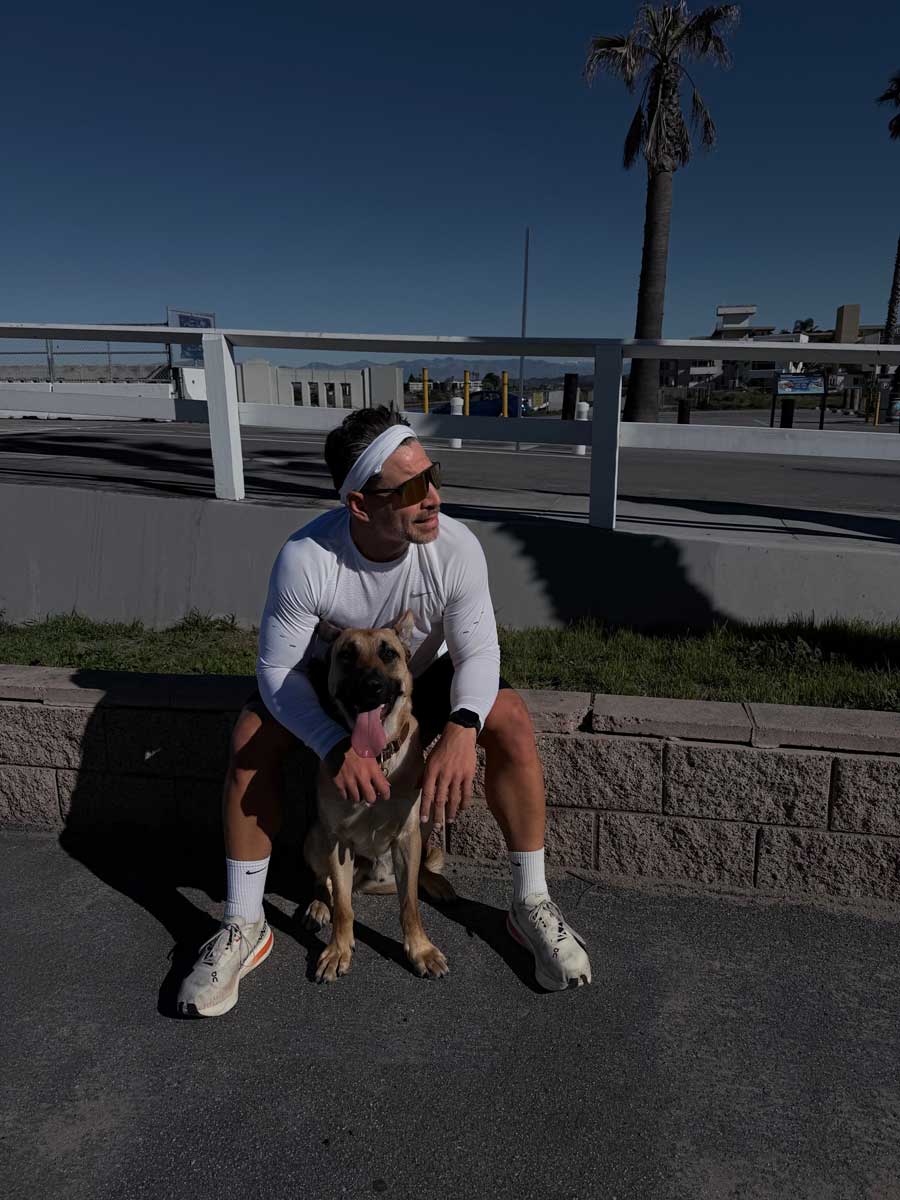 The coach is sitting with the dog.